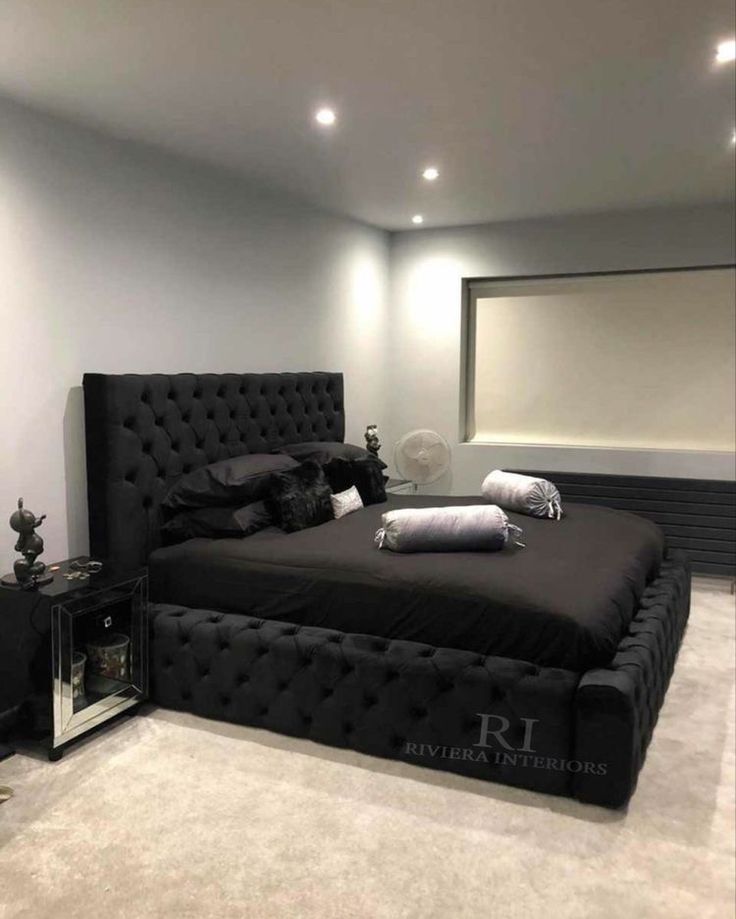 a black bed sitting in the middle of a room