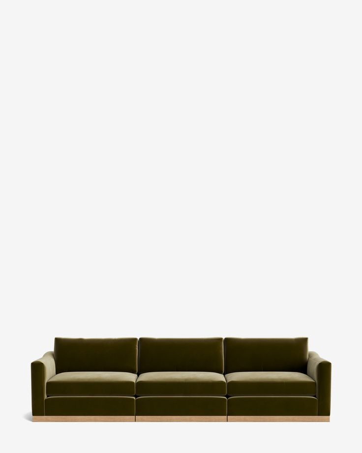 a green couch sitting in front of a white wall