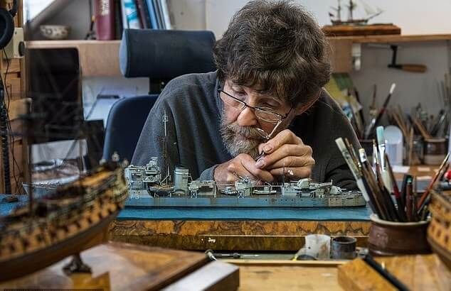 a man sitting at a desk working on something