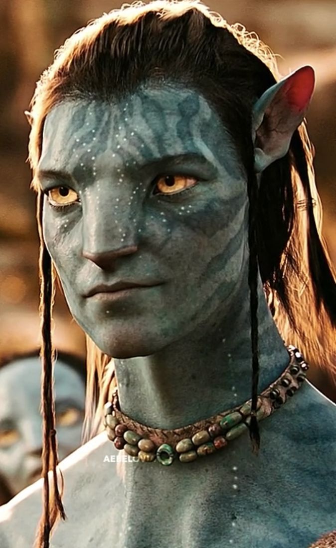 an avatar from avatar with blue skin and yellow markings on it's face is staring at the camera