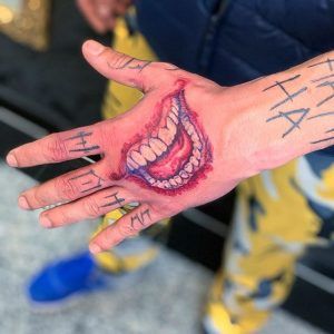 a person's hand with writing on it and an open mouth painted on the palm