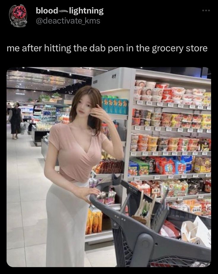 a woman is talking on her cell phone while holding a shopping cart in a grocery store