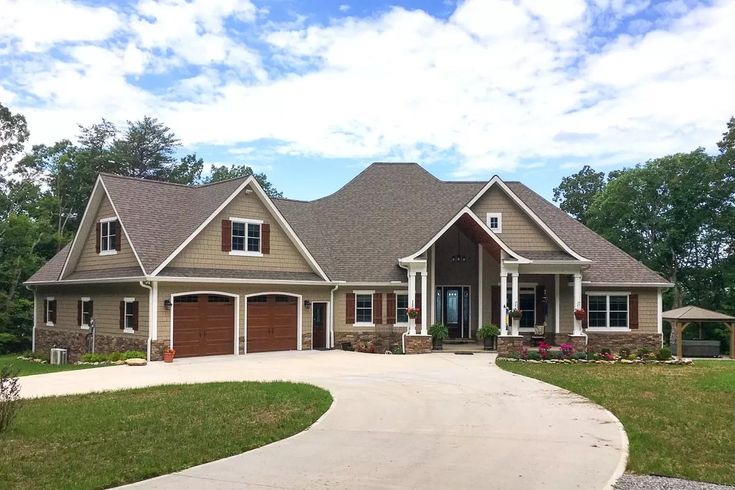 a large house with two garages and lots of windows on the front side of it