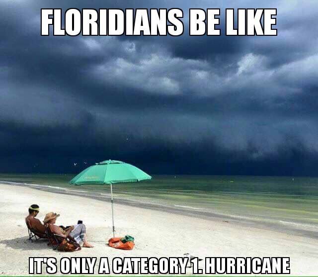 people sitting under an umbrella on the beach