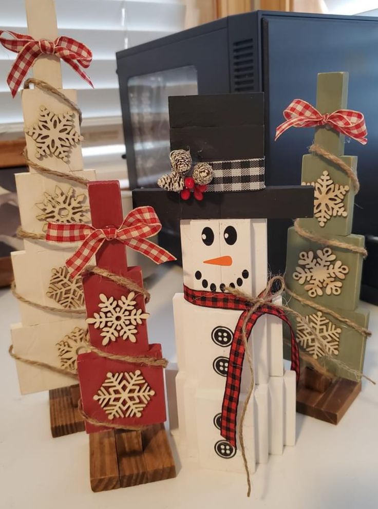 a snowman made out of wooden blocks and ribbon