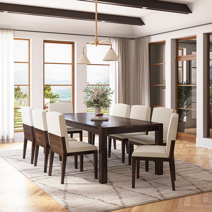 a dining room table and chairs in front of large windows