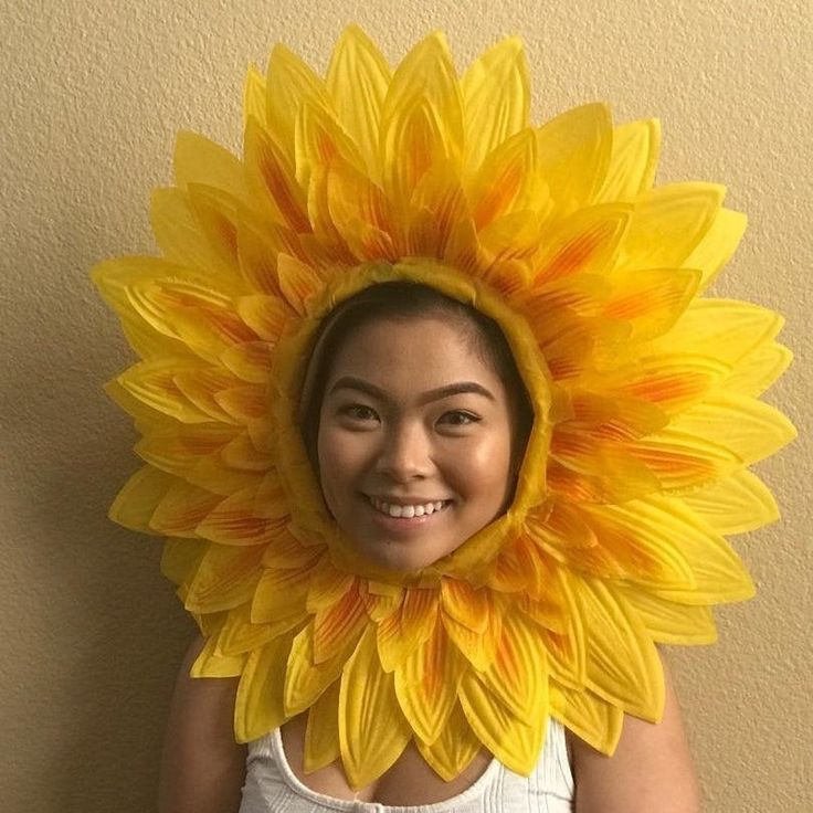 a woman wearing a sunflower mask on her head