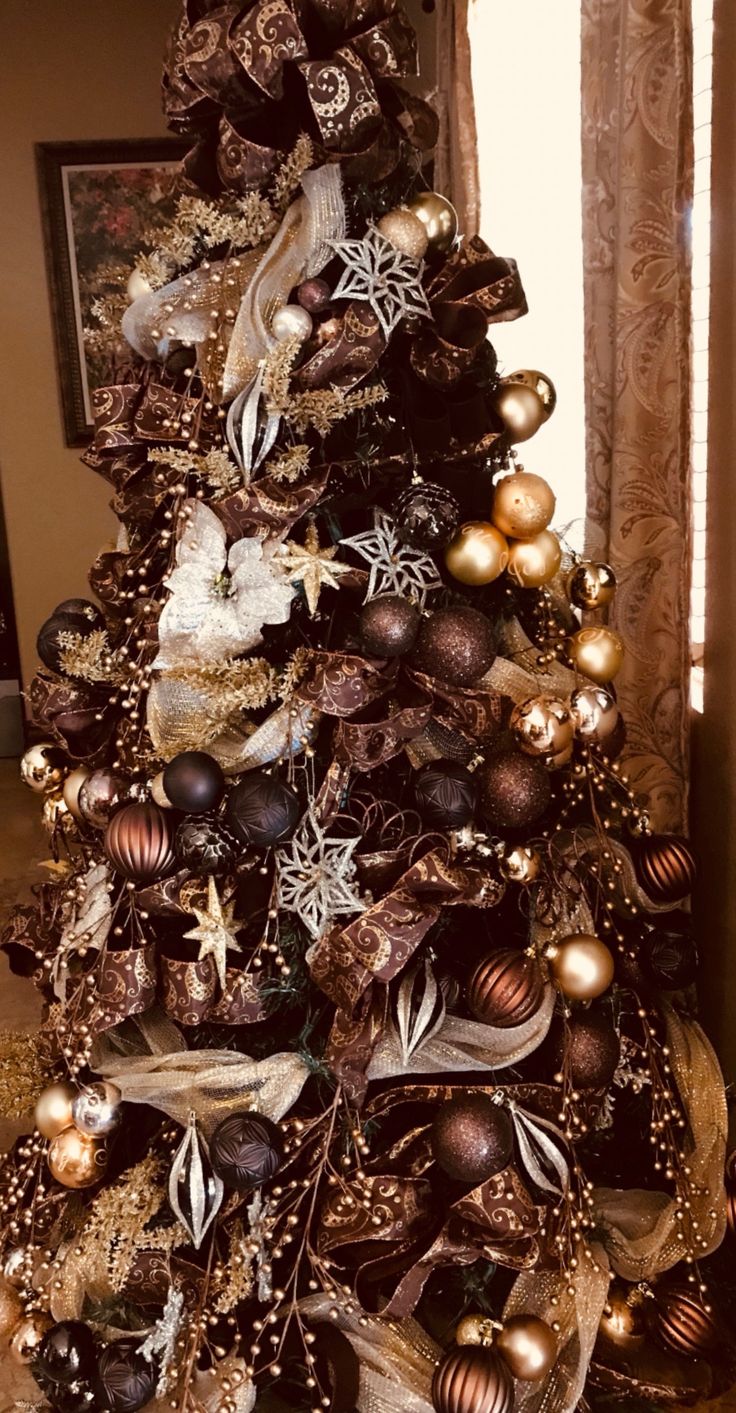 a decorated christmas tree with gold and silver ornaments