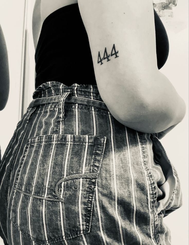 a woman with a small tattoo on her left arm and the word ma written in black ink