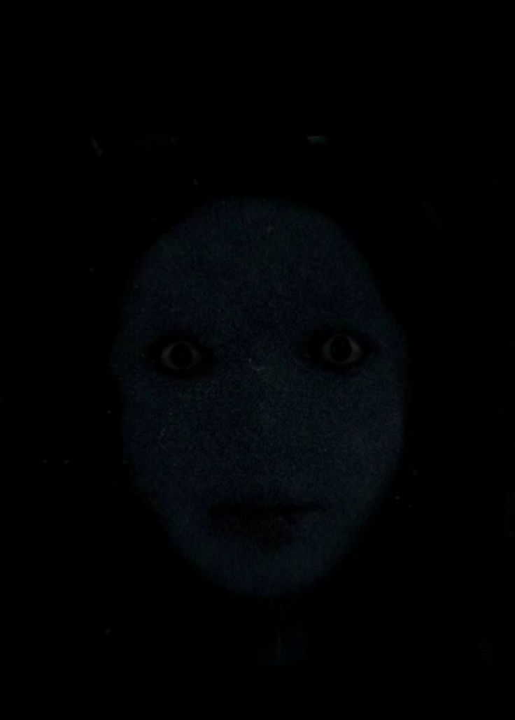 a person's face is shown in the dark