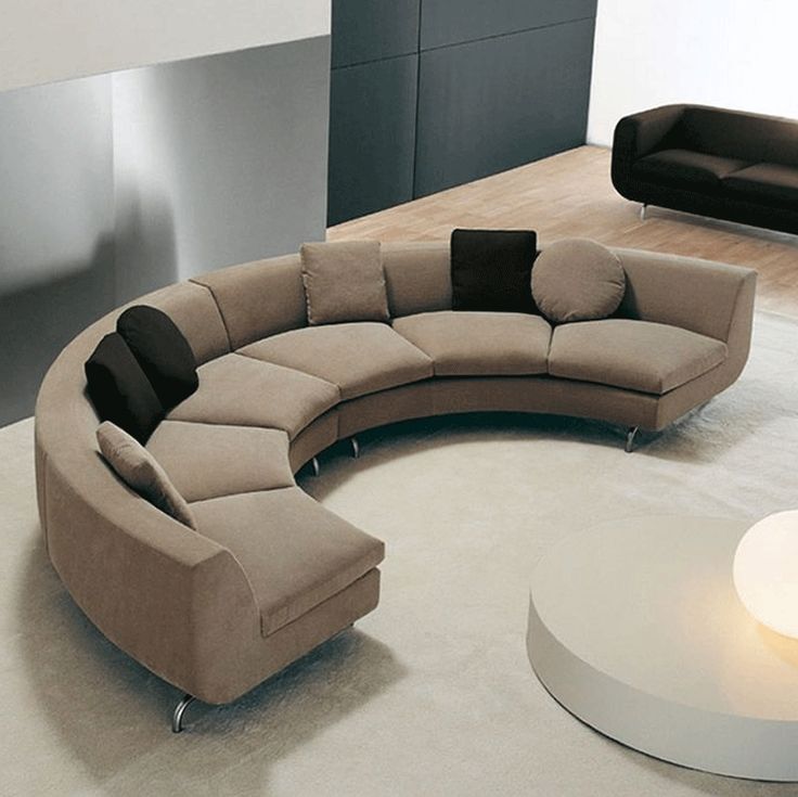 a curved couch sits in the middle of a living room