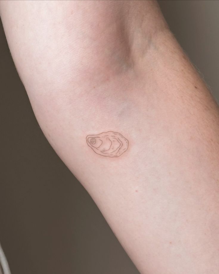 a person's arm with a small tattoo on the left side of their arm