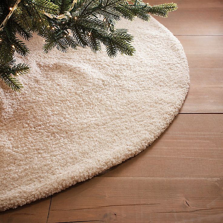 a close up of a rug on the floor with a christmas tree in the corner