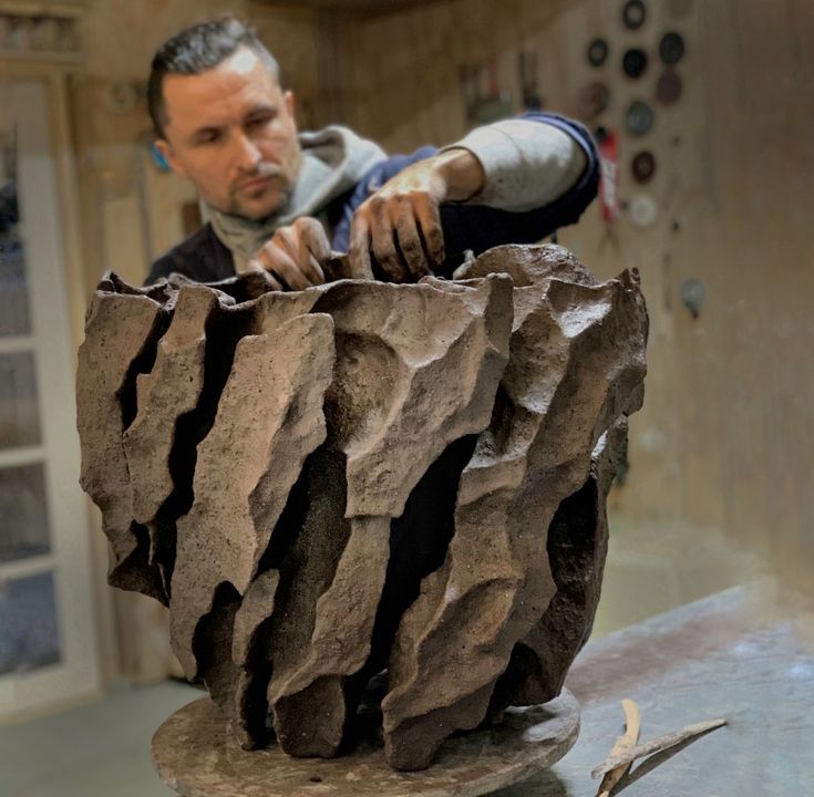 a man working on a sculpture in a studio