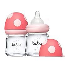 three baby bottles with pink lids and white polka dots on the top one is empty