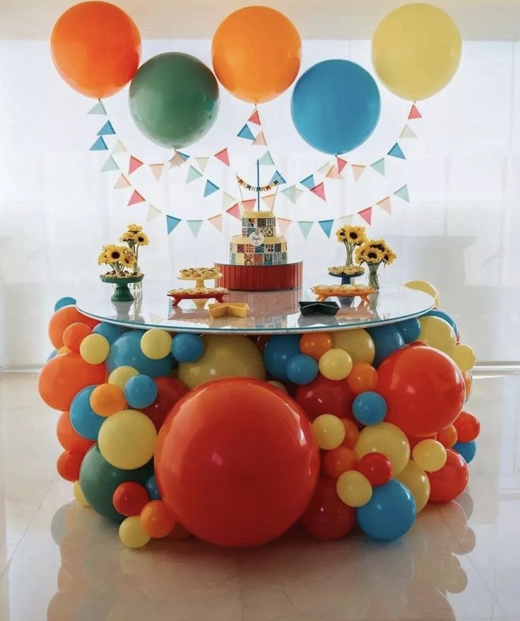 a table topped with balloons and a cake