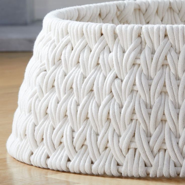 a white basket sitting on top of a wooden floor