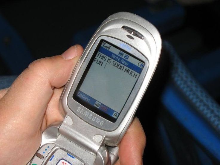 a person is holding a cell phone in their hand and pressing the button on it