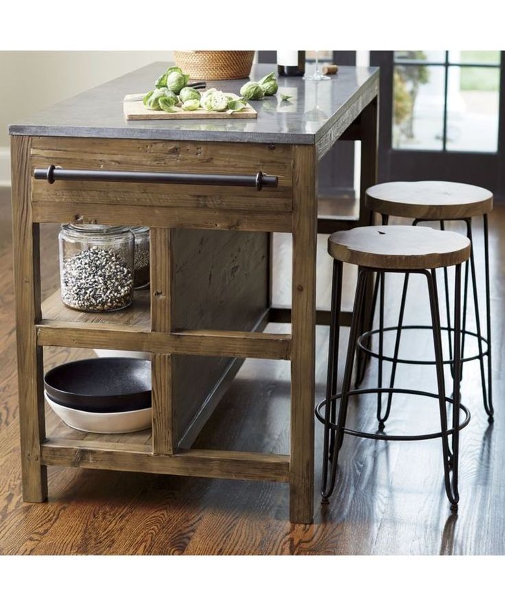 a kitchen island with two stools next to it and an open shelf on the side