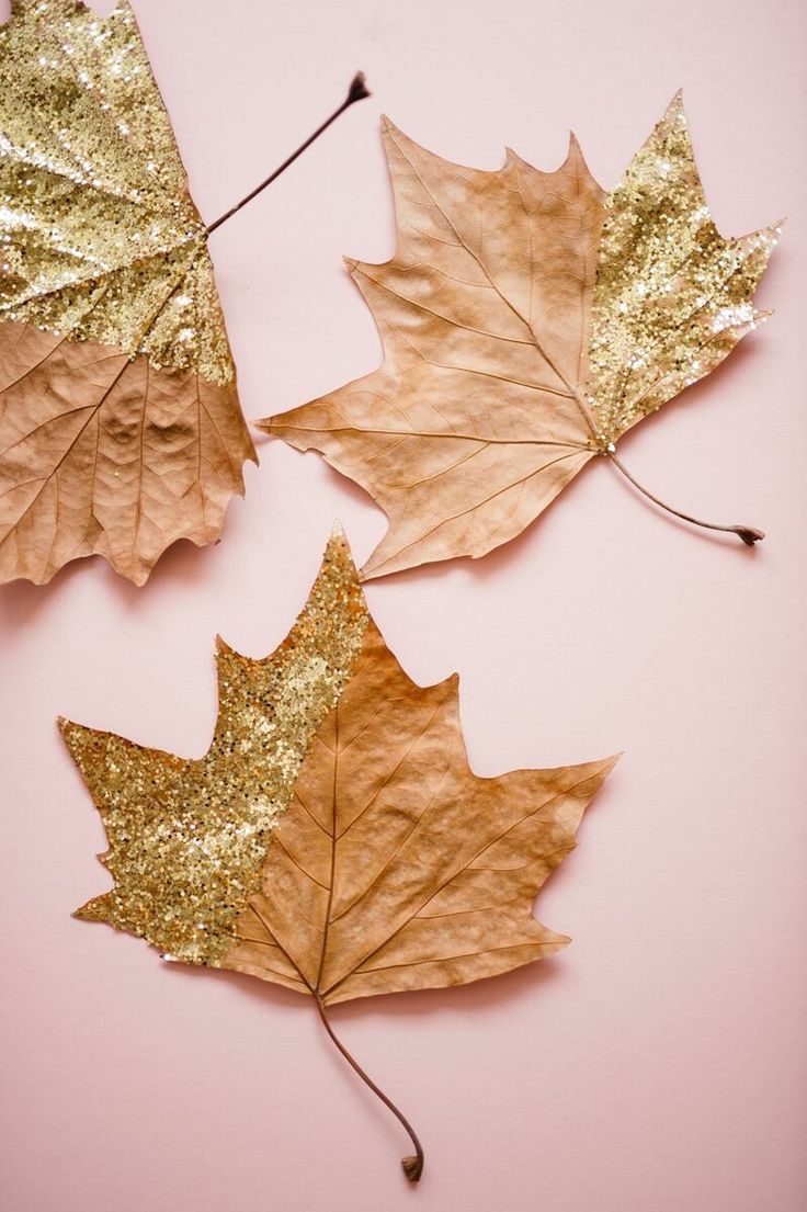 three leaves with gold glitter paint on them