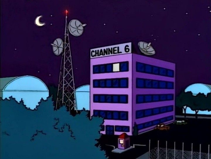 a purple building sitting in the middle of a night time scene with satellite dishes on top