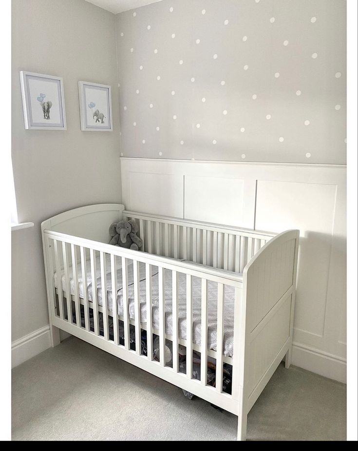 a baby's room with a white crib and polka dot wallpaper on the walls