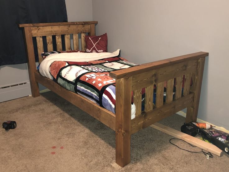 a wooden bed frame in a room with carpeting and wall decorations on the walls