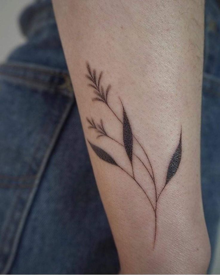 a small tattoo on the arm of a woman's left leg, with leaves