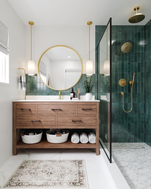 a bathroom with green tiled walls and white flooring, along with a wooden vanity topped with two round mirrors