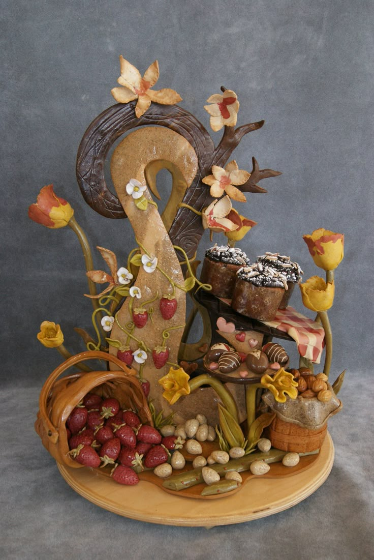 a cake with flowers, nuts and other things on it sitting on a wooden platter