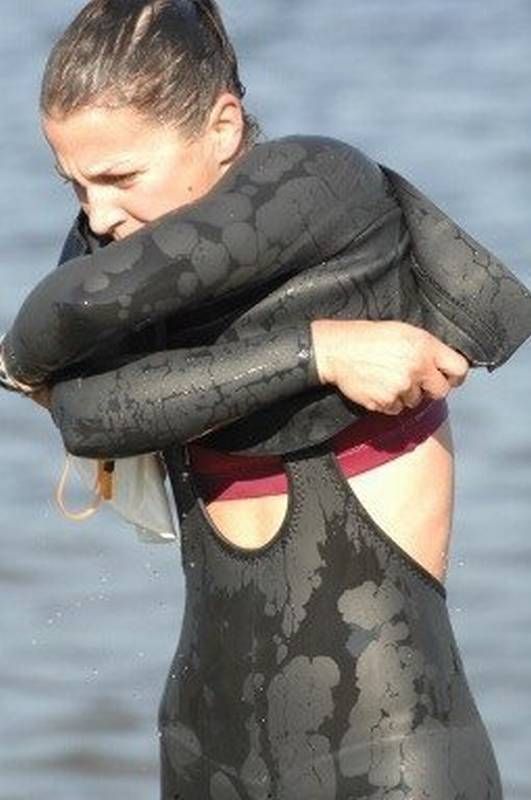 a woman in a wet suit holding onto an object