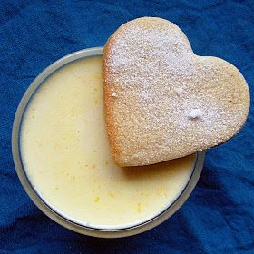 a heart shaped cookie sitting on top of a cup of milk