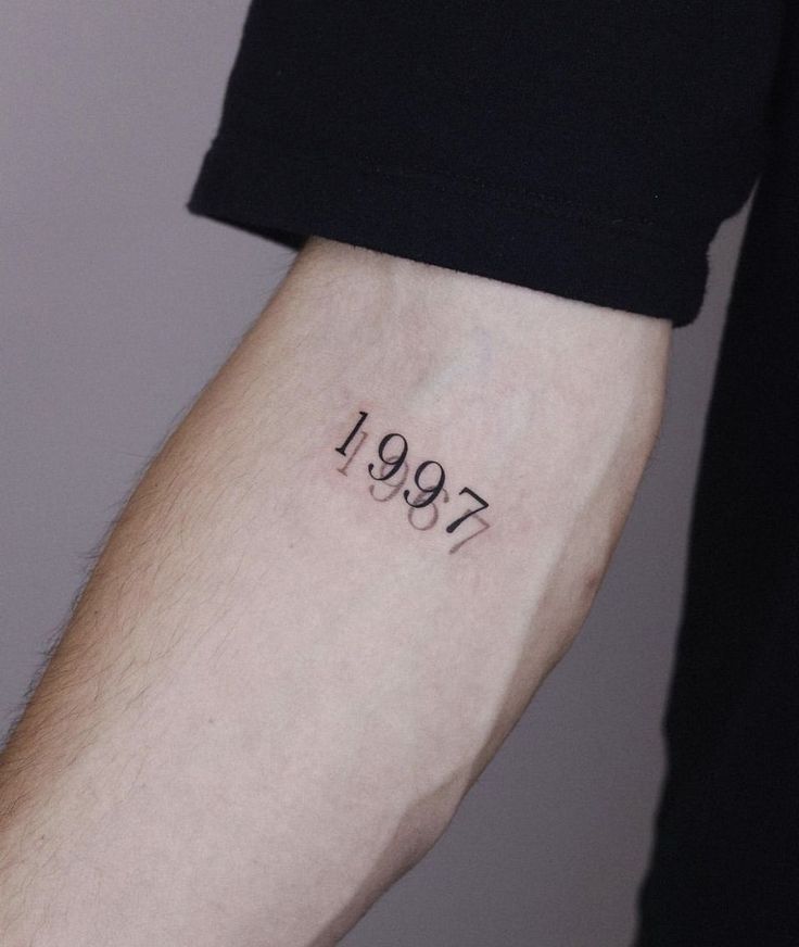 a person with a tattoo on their arm that has the number 1897 written on it