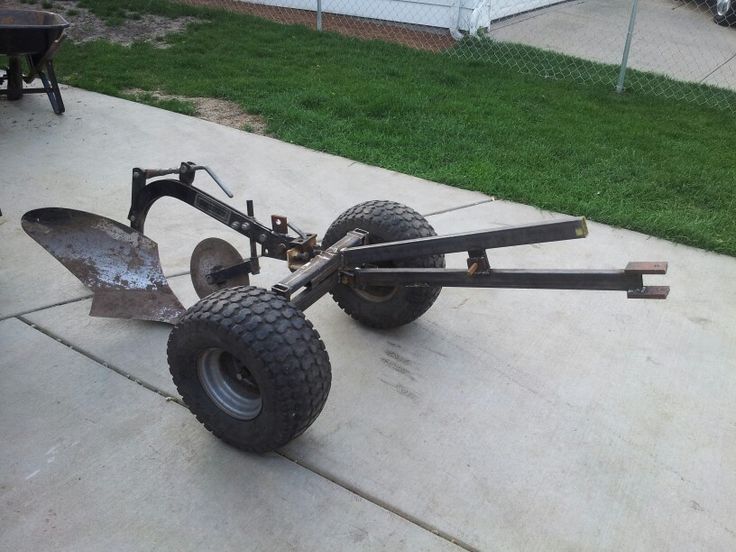 a tractor trailer attached to the back of a lawn mower with two large wheels