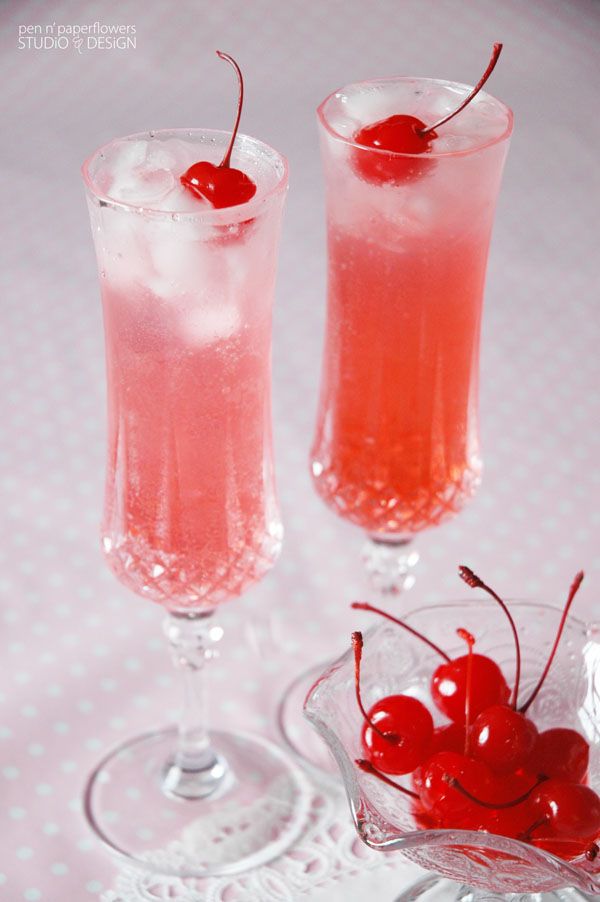 two glasses filled with liquid and topped with cherries