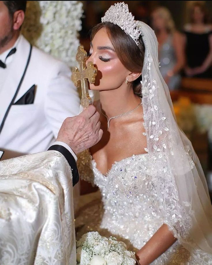 a bride and groom are getting married at their wedding ceremony with the priest looking on