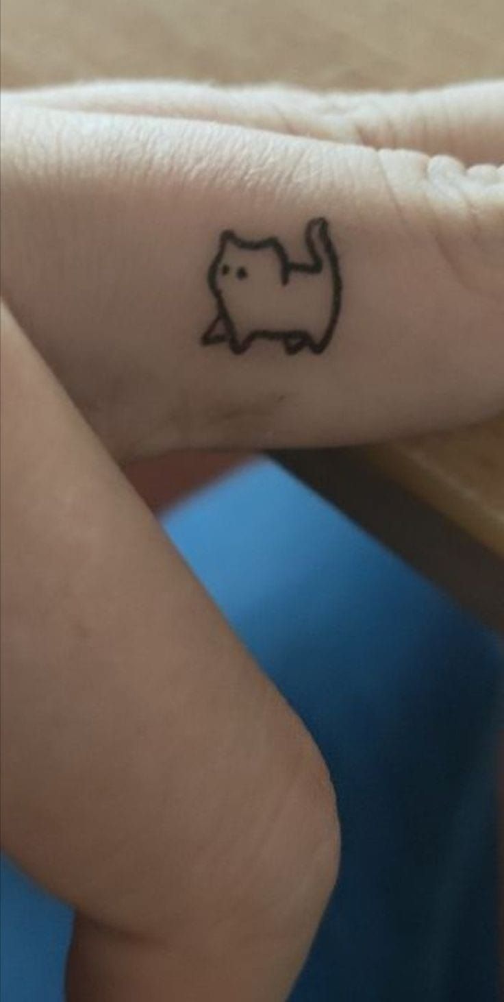 a small elephant tattoo on the left side of her right hand, with black ink