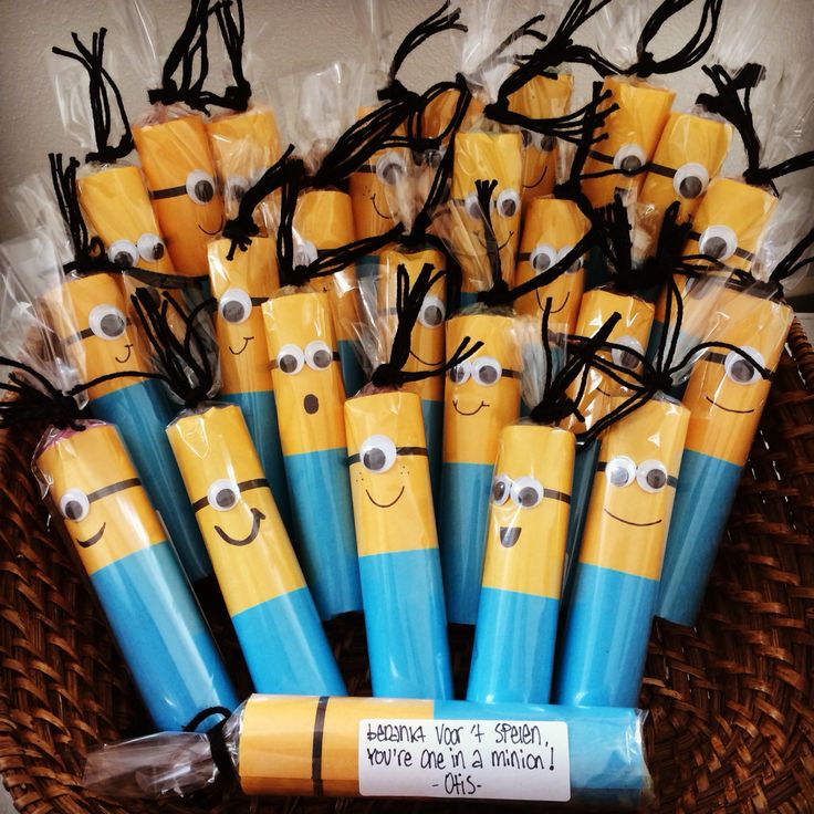 there are many yellow and blue batteries with eyes on them in a basket that is filled with plastic wrappers