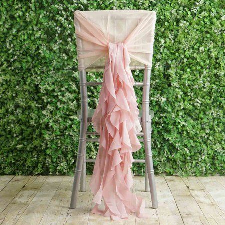 a chair with a pink ruffled sash tied to it's back in front of a green wall