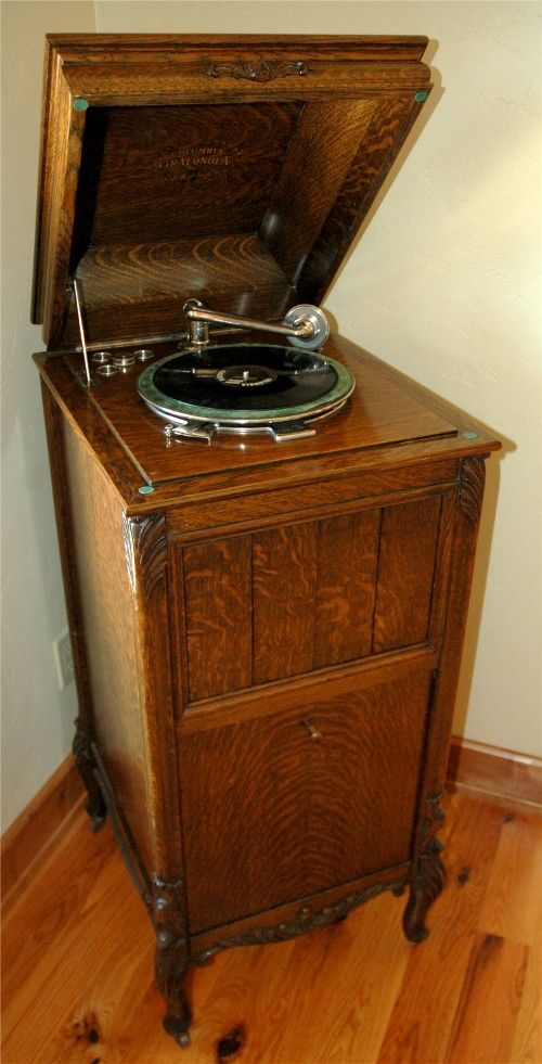 an old record player sitting on top of a wooden cabinet