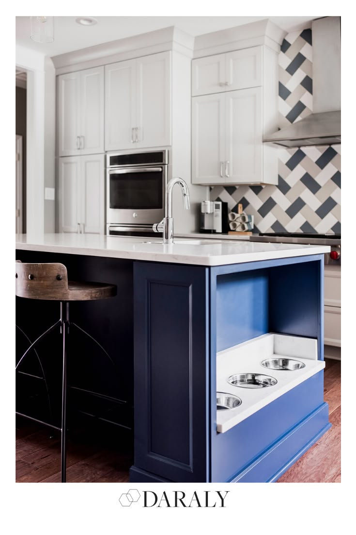 a kitchen with white cabinets and blue drawers