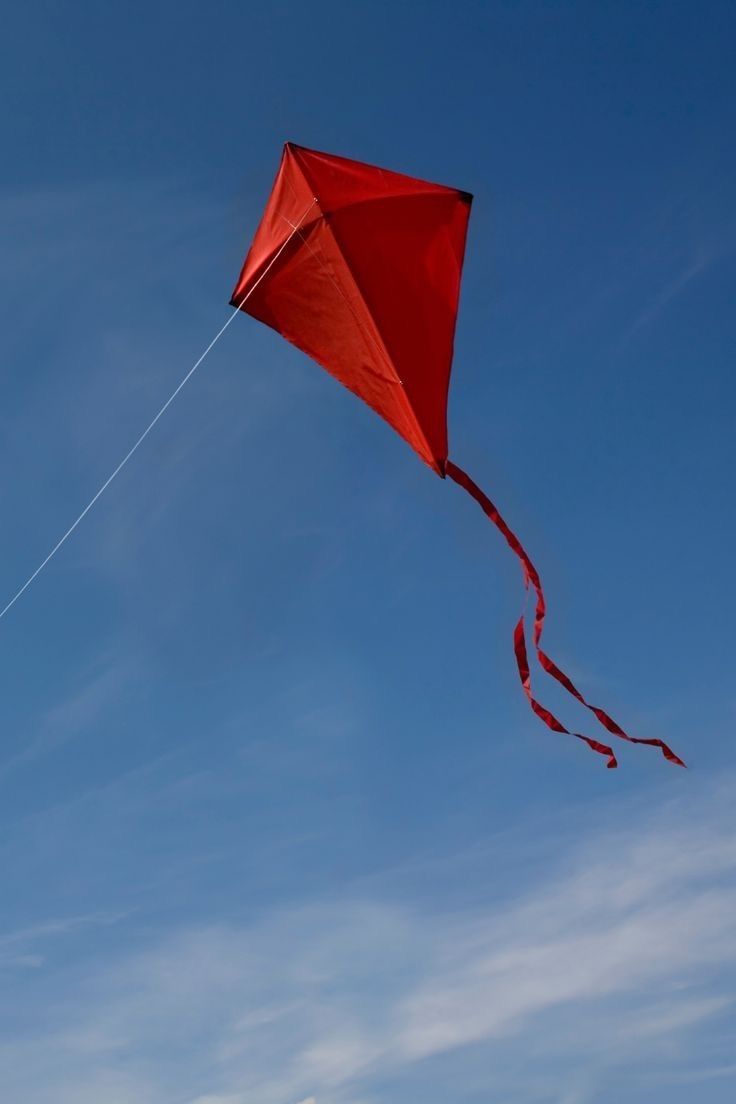 a red kite flying high in the sky