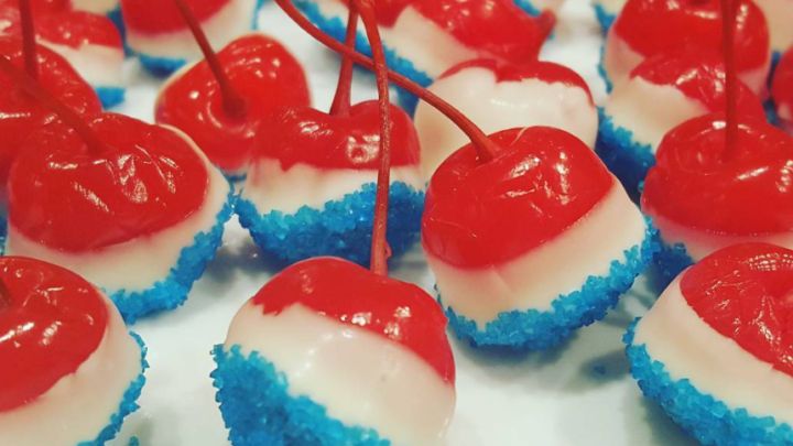 red, white and blue cupcakes with cherries on them are ready to be eaten