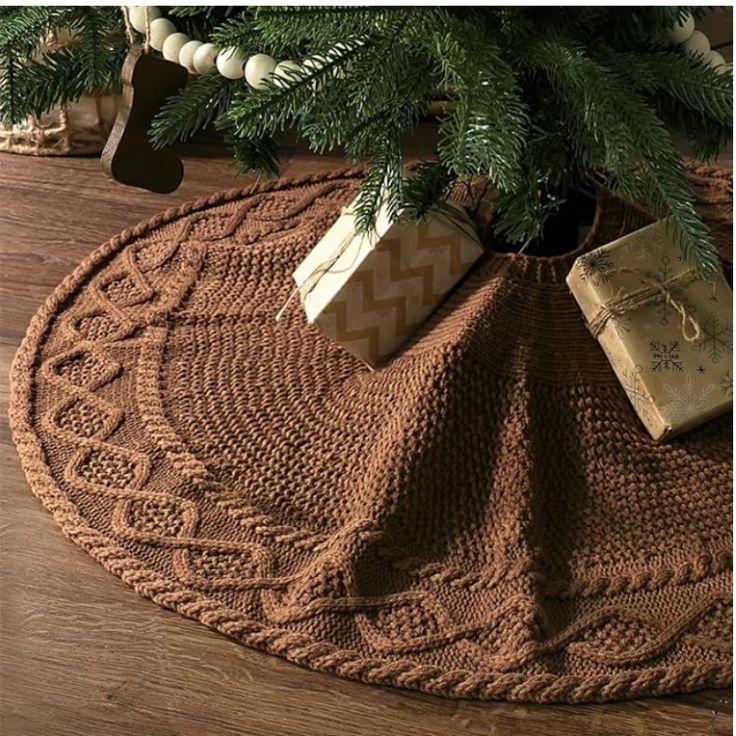 a christmas tree skirt with presents under it on the floor next to a fir tree