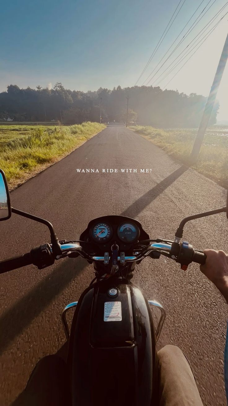 a person riding on the back of a motorcycle down a road