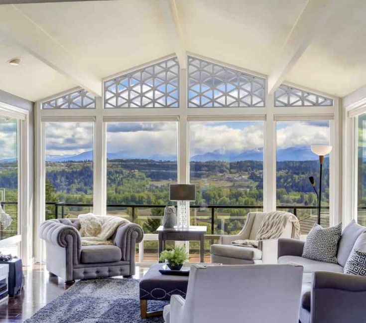 a living room filled with furniture and large windows