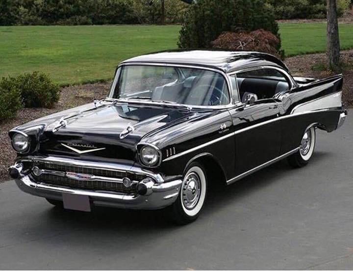 an old black and white car parked in a driveway