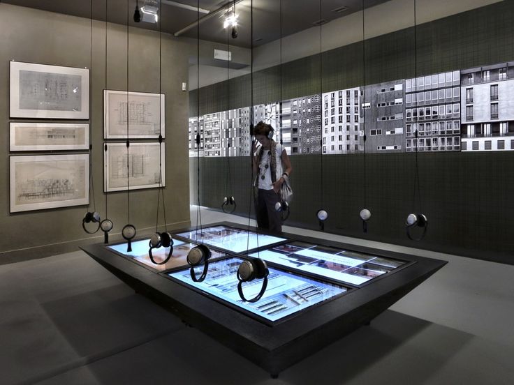 a man standing in front of a display case with headphones on it