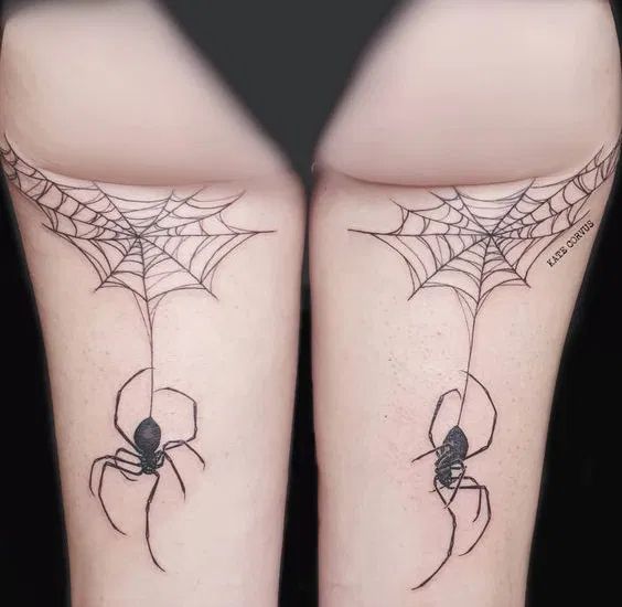 two spider web tattoos on both legs