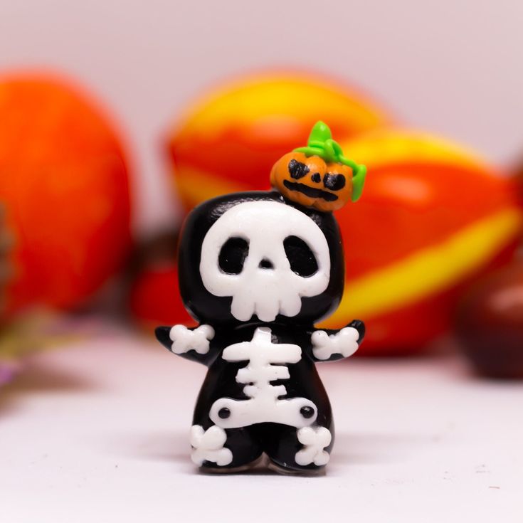 a small skeleton figurine with a pumpkin on top of it's head